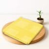 ZAHYA bamboo bath towel placed on wooden plate with small plant beside it