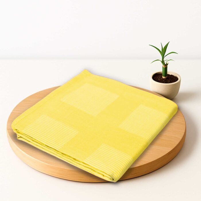 ZAHYA bamboo bath towel placed on wooden plate with small plant beside it