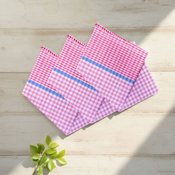 Three red check 22x22 cotton handkerchiefs neatly folded on a soft, neutral lifestyle background.