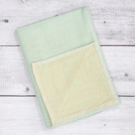 Zero twist dual layer 100 percent pure cotton bath towel neatly folded on a soft lifestyle background, showcasing plush texture and thickness